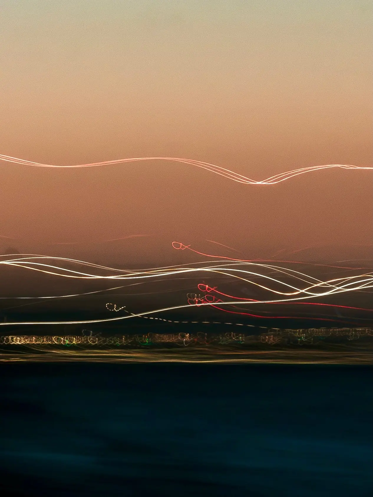 Long exposure of the sea at dusk, the waves blurred into lines of light